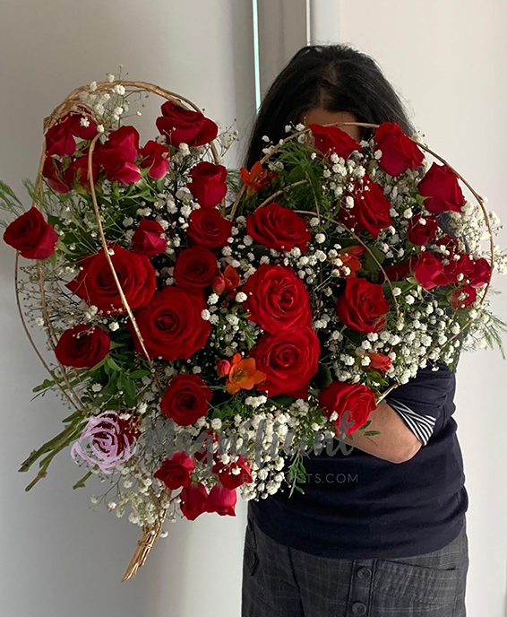 Jo Hammonds, Oadby florist, Wigston florist, Market Harborough Florist, Leicester Florist, with a heart shaped, red rose bridal bouquet