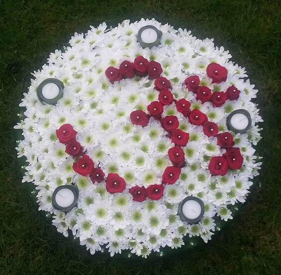 Oadby funeral flowers, Wigston funeral flowers, Om  Red Flower tribute on posy pad with tealights