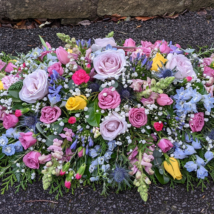 Market Harborough Funeral Flowers,  Luxury Casket spray with lilac & pink roses, white, yellow & lilac flowers, very pretty.
