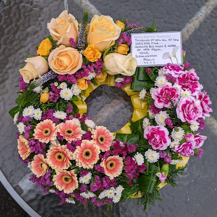 Market Harborough Funeral Flowers, Wreath ring with pink, white and purple flowers.
