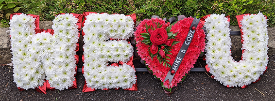 Oadby Funeral flowers, Wigston Funeral Flowers, Market Harborough Funeral Flowers, Leicester Funeral Flowers, WE LOVE YOU tribute, contemporary style, red white & black flowers & ribbons