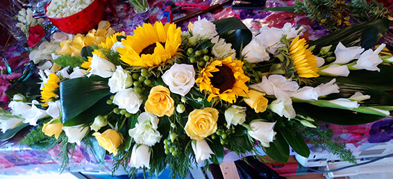 Oadby Funeral Flowers, Wigston Funeral flowers, Leicester funeral flowers, Lemon and white flower sunflowers Casket spray