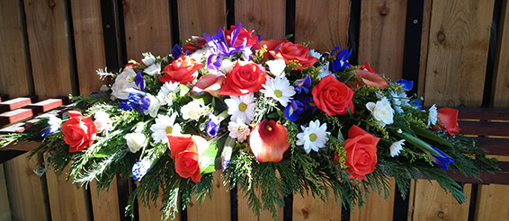 Oadby Funeral Flowers, Wigston Funeral flowers, Leicester funeral flowers, Orange roses, iris, white flower Casket spray
