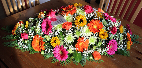 Oadby Funeral Flowers, Wigston Funeral flowers, Colourful gerbera and sunflower Casket spray