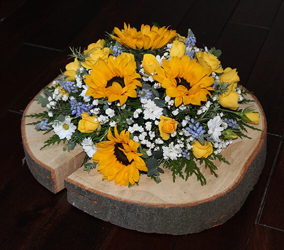 Oadby Funeral Flowers, Wigston Funeral Flowers, Market Harborough Funeral Flowers, Posy Tribute on wood slice with sunflowers, conetemporary style