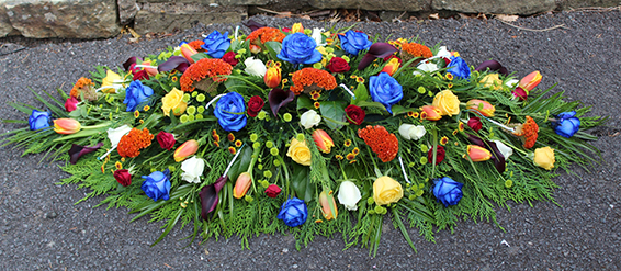 Oadby Funeral Flowers, Wigston Funeral Flowers, Leicester funeral flowers, Kenyan Maasai colours with blue roses Casket Spray