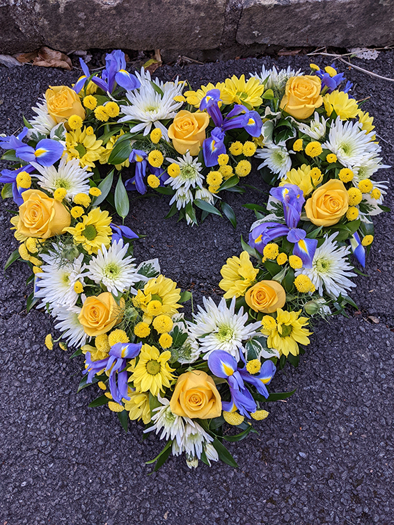 Oadby Funeral Flowers, Wigston Funeral Flowers, Market Harborough Funeral Flowers, Leicester Funeral Flowers, Loose Open Heart Tribute, yellow & white flowers with blue iris.