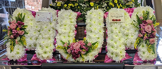 Oadby Funeral flowers, Wigston Funeral Flowers, Market Harborough Funeral Flowers, Leicester Funeral Flowers, MUM tribute, traditional style, white base with hot pink & yellow flower sprays & ribbons