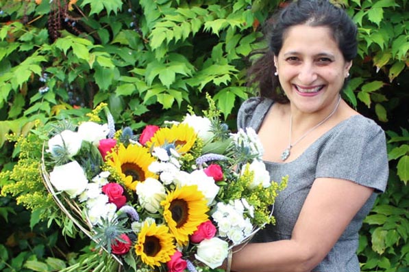 Oadby florist, Wigston florist, Jo hammonds holding a heart shaped bouquet of sunflowers and hot pink roses