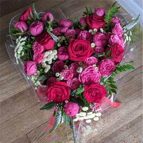 Oadby florist, Wigston florist, Heart shaped handtied bouquet, with red and with roses and lilac statice, wrapped in red tissue paper